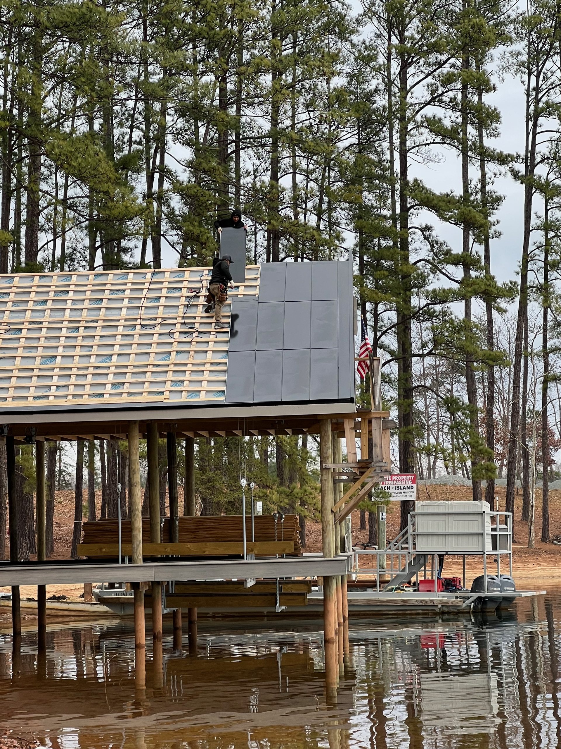 Boathouse solar roof installation seen from the water